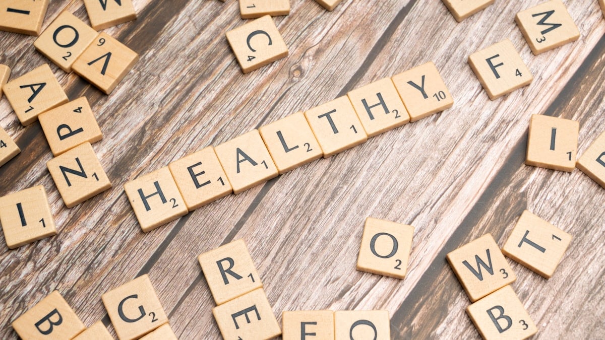 scrabble tiles spelling out the word healthy on a wooden surface